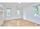 Bright bedroom features wood floors, three windows, and shelving at 2334 Dawn Trl, Durham, NC 27712