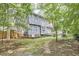 Rear exterior with siding and many windows overlooks the lush yard and landscaping beyond the rear fence at 2334 Dawn Trl, Durham, NC 27712