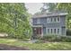 Two-story home with a red door and well-maintained front yard surrounded by mature trees and shrubbery at 2334 Dawn Trl, Durham, NC 27712