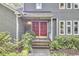 Close-up of the front entrance featuring a double red door with decorative details and well-kept landscaping at 2334 Dawn Trl, Durham, NC 27712