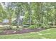 Mature trees and lush landscaping frame this beautiful home, complete with a well-maintained lawn at 2334 Dawn Trl, Durham, NC 27712