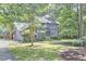 Lush greenery surrounds this two-story home, creating a private setting with mature trees and manicured lawn at 2334 Dawn Trl, Durham, NC 27712