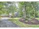 A long driveway and lush trees beautifully frame the home's exterior, complementing the manicured lawn at 2334 Dawn Trl, Durham, NC 27712