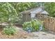 Cozy backyard outbuilding featuring blue hydrangeas and a charming wooden fence, surrounded by lush greenery at 2334 Dawn Trl, Durham, NC 27712
