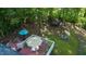 Aerial view of a backyard featuring a deck, trampoline, playground set and mature trees at 2410 Wade Hampton Rd, Hillsborough, NC 27278