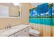 Bright bathroom featuring a tropical-themed shower curtain, white vanity and neutral walls at 2410 Wade Hampton Rd, Hillsborough, NC 27278