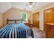 Cozy bedroom with a blue striped bedspread, wooden floors and a window allowing natural light at 2410 Wade Hampton Rd, Hillsborough, NC 27278