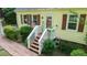 Quaint front porch featuring an American flag, brick walkway, and well-maintained landscaping at 2410 Wade Hampton Rd, Hillsborough, NC 27278