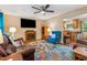 Cozy living room featuring a fireplace, hardwood floors, a ceiling fan, and a colorful patterned rug at 2410 Wade Hampton Rd, Hillsborough, NC 27278