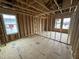 Unfinished bedroom showing the stud framing, open floorplan, and light coming in from a window at 29 Chloe Ct, Selma, NC 27576