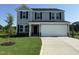 Charming two-story home with a gray exterior, black shutters, attached garage, and newly laid lawn and landscaping at 29 Chloe Ct, Selma, NC 27576