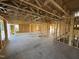 Unfinished living room showing open layout with stud walls, concrete floor, and doorway leading to the backyard at 29 Chloe Ct, Selma, NC 27576