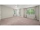 Spacious bedroom with soft carpet, featuring neutral walls and three large windows for ample natural light at 2920 Barrymore St # 106, Raleigh, NC 27603