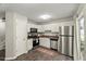 Cozy kitchen with white cabinets and stainless steel appliances, leading to outdoor scenery at 2920 Barrymore St # 106, Raleigh, NC 27603