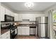 Updated kitchen features stainless appliances, white cabinetry, and a view to the backyard at 2920 Barrymore St # 106, Raleigh, NC 27603