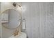 Stylish powder room with patterned wallpaper, gold fixtures, and decorative round mirror at 2920 Barrymore St # 106, Raleigh, NC 27603