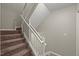 Stairway with carpet on stairs and a white railing at 2920 Barrymore St # 106, Raleigh, NC 27603