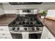 Close up of stainless steel gas range and cooktop, with a cookbook displayed at 2920 Barrymore St # 106, Raleigh, NC 27603