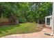 Lush backyard with a playhouse and flagstone path to the screened in porch, framed by mature trees at 3 White Ash Dr, Durham, NC 27712