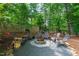 Cozy backyard fire pit area with seating, surrounded by lush greenery and mature trees, perfect for gatherings at 3 White Ash Dr, Durham, NC 27712