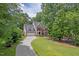 Elegant brick home with a well-manicured lawn and a long driveway, nestled among mature trees at 3 White Ash Dr, Durham, NC 27712