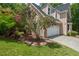 Beautiful home exterior featuring a blooming pink tree near the garage and walkway through the gated back yard at 3 White Ash Dr, Durham, NC 27712