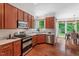 Bright eat-in kitchen with stainless steel appliances, wooden cabinets, and hardwood floors at 3 White Ash Dr, Durham, NC 27712
