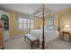 A bright bedroom features a canopy bed, neutral carpet, and a window, creating a peaceful retreat at 31 W Madison, Pittsboro, NC 27312