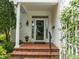 Close-up of the front door, featuring elegant details, a wreath, and stylish outdoor lighting at 31 W Madison, Pittsboro, NC 27312