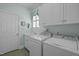 Bright laundry room offers a sink, white cabinetry, and modern washer and dryer at 31 W Madison, Pittsboro, NC 27312