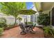 This patio features a brick-paved surface, outdoor seating, and an umbrella for shade, perfect for enjoying the outdoors at 31 W Madison, Pittsboro, NC 27312