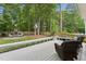 Inviting deck area with seating overlooks a lush backyard with a stone fireplace and mature trees at 325 Wescott Ridge Dr, Holly Springs, NC 27540