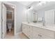 Well-lit bathroom with double sinks, a large mirror, and modern fixtures, offering a clean and functional design at 325 Wescott Ridge Dr, Holly Springs, NC 27540