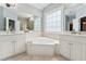 Bright bathroom with double sinks, a soaking tub, and a large window for ample natural light at 325 Wescott Ridge Dr, Holly Springs, NC 27540