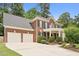 Traditional brick home with a two-car garage, manicured landscaping, and a welcoming front porch with white pillars at 325 Wescott Ridge Dr, Holly Springs, NC 27540