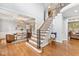 Elegant foyer with hardwood floors, a staircase with iron railings, and a view into the dining room with a coffered ceiling at 325 Wescott Ridge Dr, Holly Springs, NC 27540