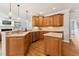 Well-lit kitchen showcasing wooden cabinets, a spacious island, and stainless steel appliances at 325 Wescott Ridge Dr, Holly Springs, NC 27540