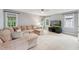 Spacious living room with large sectional sofa, multiple windows, and a modern entertainment center at 325 Wescott Ridge Dr, Holly Springs, NC 27540