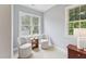 Bright sitting area with natural light from the windows, comfy seating, and a small wooden table at 325 Wescott Ridge Dr, Holly Springs, NC 27540