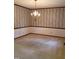 Formal dining room with neutral carpet, classic chandelier and wallpapered accent wall at 3300 Barnsley Ln, Raleigh, NC 27604