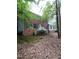 Traditional brick home with white accents, a welcoming porch, and surrounded by mature trees for privacy at 3300 Barnsley Ln, Raleigh, NC 27604