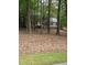 Classic two-story brick home with green shutters surrounded by trees, offering a secluded and private setting at 3300 Barnsley Ln, Raleigh, NC 27604