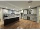 Spacious kitchen boasts white cabinets, granite countertops, stainless steel appliances, an island with dark wood and breakfast bar at 35 Big Bear Dr, Pittsboro, NC 27312