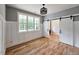 Versatile room featuring neutral paint, hardwood floors, a modern light fixture, and sliding barn doors leading to another room at 35 Big Bear Dr, Pittsboro, NC 27312