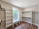 Functional walk-in closet with built-in shelving, wood flooring, and a window seat overlooking the outdoors at 35 Big Bear Dr, Pittsboro, NC 27312