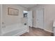 Bathroom showcasing a soaking tub, wood-look floors, and a neutral color scheme at 40 Otter Ct, Youngsville, NC 27596