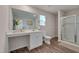 Bathroom featuring a glass door shower, wood-look floors, and white cabinets at 40 Otter Ct, Youngsville, NC 27596