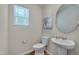 Clean bathroom featuring a pedestal sink, white fixtures, and natural light from the window at 40 Otter Ct, Youngsville, NC 27596