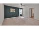 Large bedroom featuring a dark accent wall, window, ceiling fan, and neutral carpet at 40 Otter Ct, Youngsville, NC 27596