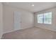 Bedroom featuring neutral colored walls and carpet with a window and a white door at 40 Otter Ct, Youngsville, NC 27596